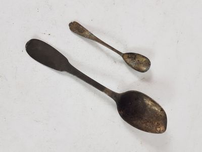 two spoons and a spoon rest on a white surface