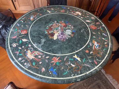une table en marbre sur laquelle sont disposées des fleurs, dans un salon