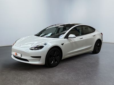 a white tesla model 3 parked in a white room