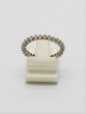 un gros plan d'une bague posée sur un support, sur une surface blanche