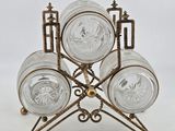 three clear glass dishes on a metal stand on a white background