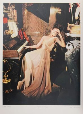 an image of a woman in a long dress sitting at a piano