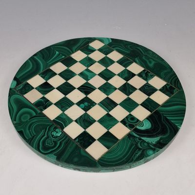 un échiquier vert et blanc posé sur une table blanche
