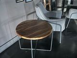 two chairs and a table in a room with pictures on the wall