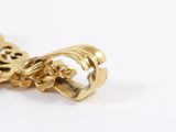 a close up of a gold necklace on a white surface
