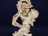 porcelain figurine of a cupid holding a basket of flowers
