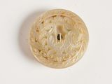 un bouton en ivoire orné d’un motif floral sur un fond blanc