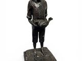 statue of a boy with a book in his hands on a black base