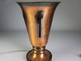 un vase en or posé sur une table, avec un cordon