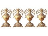 quatre vases en laiton vieilli sont alignés sur un fond blanc