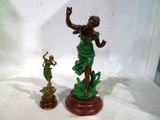 une statue représentant une femme et une figurine posées sur une table