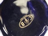 a blue and white vase with a gold emblem on it