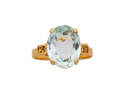 un gros plan d'une bague en or sertie d'une aigue-marine ovale