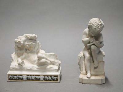two white statues of a boy and a dog on a table