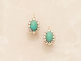 pair of turquoise and diamond stud earrings on a marble surface
