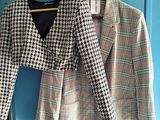 houndsered blazer jacket on a hanger in front of a blue door