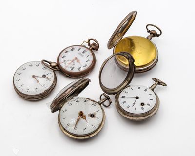 plusieurs montres de poche anciennes empilées les unes sur les autres sur une surface blanche