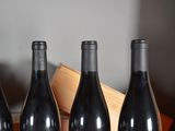 three bottles of wine sit on a table next to a box of wine