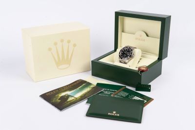 une boîte avec une montre à l'intérieur sur une surface blanche