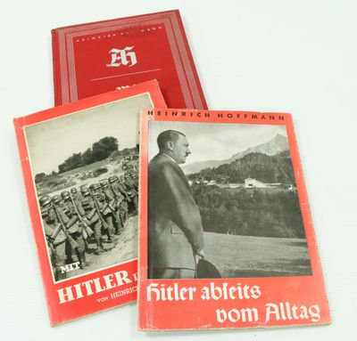 deux livres rouges avec des photos d'Hitler et d'un homme en costume