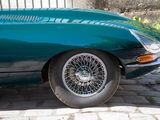 a green sports car parked on a cobblestone street