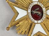 an image of a gold medal with a red and white star on it