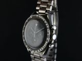 close up of a watch on a black surface with a black background