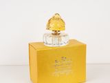 an image of a bottle of perfume sitting on top of a yellow box