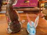 two figurines of a cat and a rabbit sitting on a table