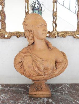 a bust of a woman sitting on a marble table