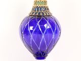 a blue glass vase with a gold top on a white background