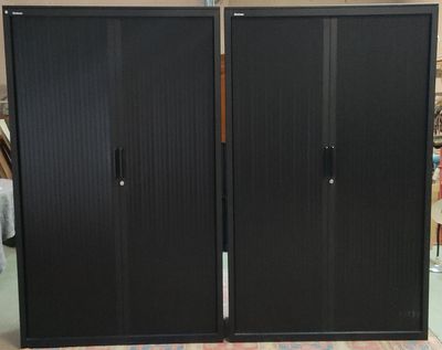 une grande armoire noire au milieu d'une pièce