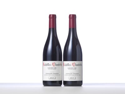 two bottles of red wine sitting on top of a table