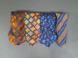 four different colored ties are lined up on a gray surface