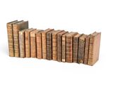 several old books stacked on top of each other on a white surface