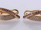 a pair of brown and white diamond earrings on a white surface
