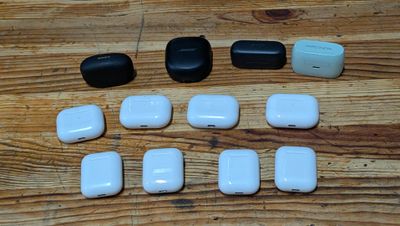 many white and black airpods sitting on a wooden table