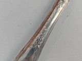 a silver plate with a knife on it on a table