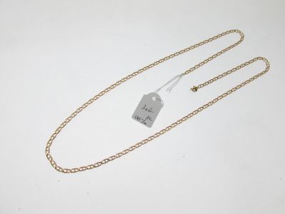 une chaîne en or à laquelle est accrochée une médaille, posée sur une surface blanche