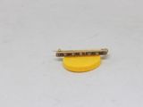 a small yellow piece of jewelry sitting on top of a white surface