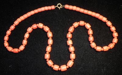 un gros plan d'un collier composé de perles orange sur un fond noir