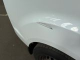 a close up of a white car with a denting on it