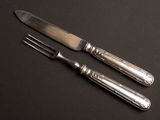 deux fourchettes et un couteau posés sur une table noire