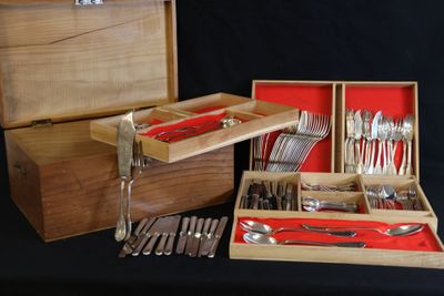 une boîte en bois contenant de l'argenterie, sur fond noir