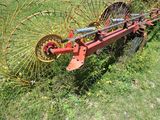 a red and yellow tractor with a plow attached to it ' s back