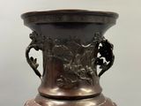un grand vase en bronze orné d'un motif floral