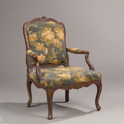 a chair with a floral upholstered back and arms