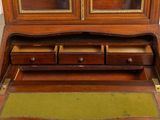 an old wooden desk with drawers and a rug on the floor