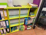 a green shelf with many files and binders on it