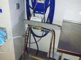 a blue hose attached to a metal stand in a bathroom